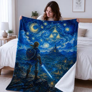 May include: A plush throw blanket featuring a vibrant, painterly illustration of a warrior standing on a cliff overlooking a castle at night. The scene includes a glowing blue sword, a shield with a golden emblem, and a swirling starry sky.