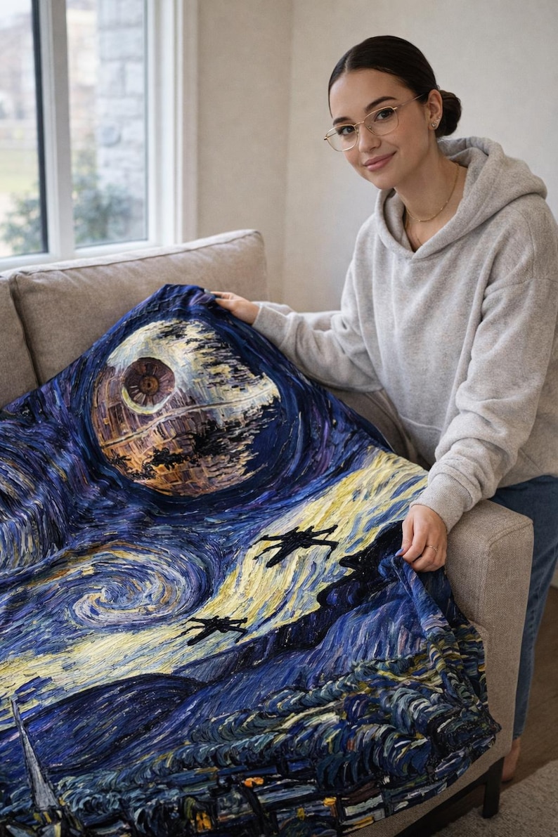 May include: A blue blanket featuring a stylized depiction of the Death Star and X-wing fighters against a swirling night sky, reminiscent of Van Gogh's "Starry Night." The blanket is a blend of dark blues, yellows, and browns.