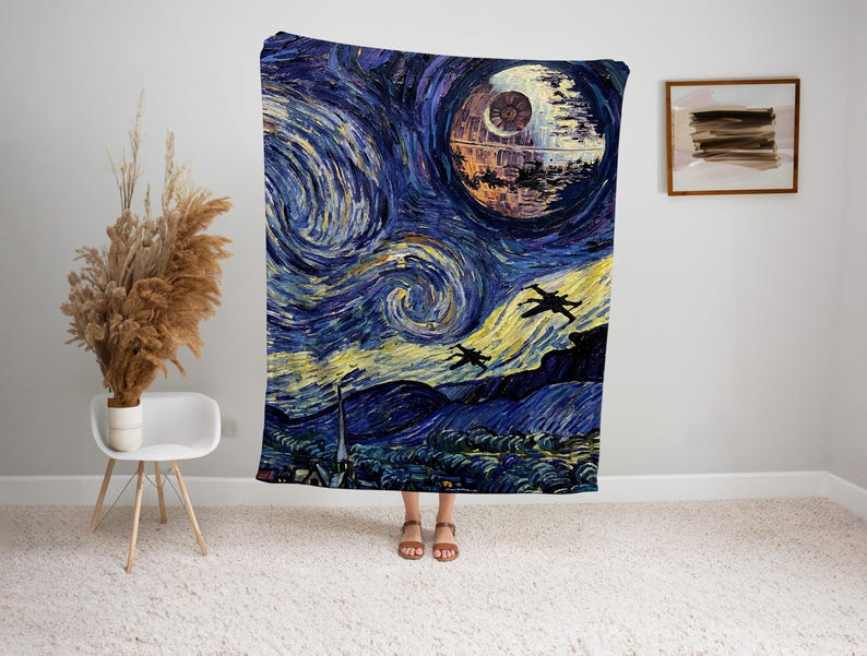 May include: A large, rectangular blanket featuring a stylized painting of a space scene. The design incorporates elements of Van Gogh's "Starry Night" with a Death Star and X-wing fighters. The color palette includes blues, yellows, and dark hues.