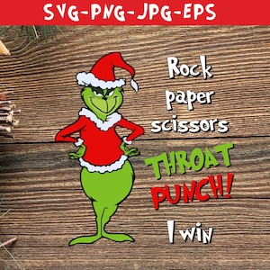 Może przedstawiać: Zielona postać Grincha w czerwonym kapeluszu Świętego Mikołaja i czerwono-białym stroju. Grinch stoi na drewnianym tle z tekstem "Papier kamień nożyczki Cios w gardło! Wygrałem".