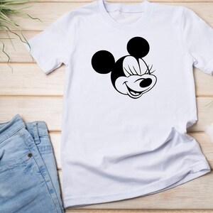 Peut inclure: T-shirt blanc avec une illustration noir et blanc de Minnie Mouse les yeux ferm&eacute;s.