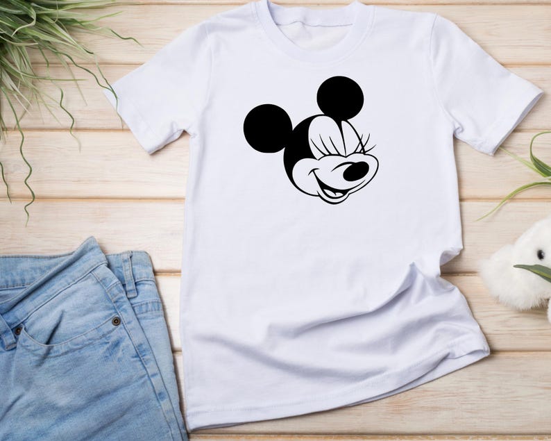 Peut inclure: T-shirt blanc avec une illustration noir et blanc de Minnie Mouse les yeux ferm&eacute;s.