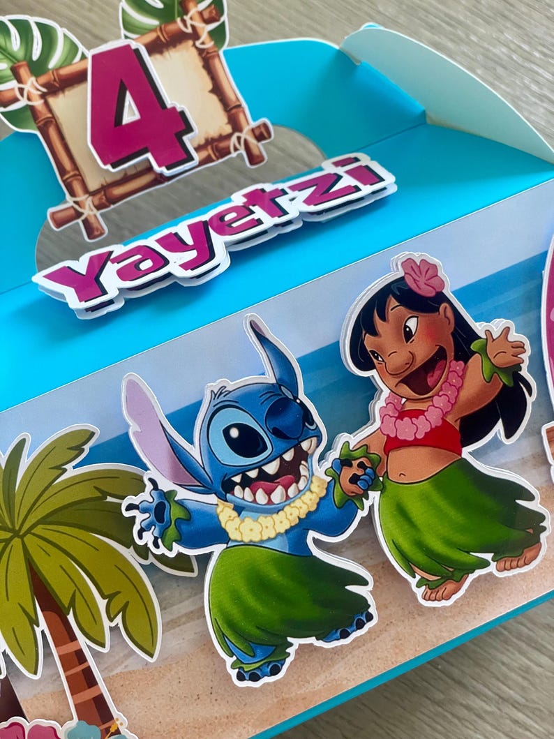 May include: A blue party favor box featuring the characters Stitch and Lilo from the movie Lilo & Stitch. The box has a tropical theme with palm trees, a sandy beach, and the number 4. The name "Yayertzi" is also displayed.