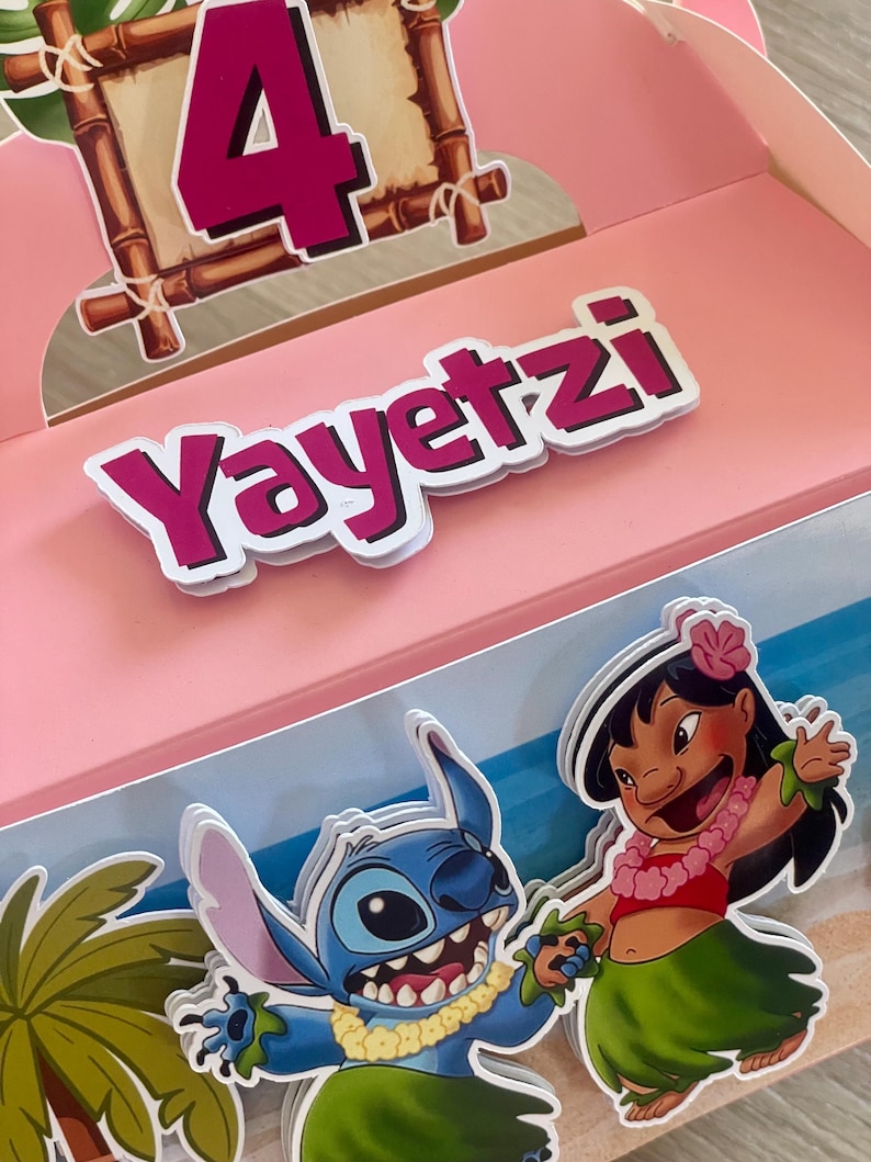 May include: Pink party favor box with the name "Yayetzl" in white letters with a pink outline. The box features a number 4 in pink, a cartoon of Stitch and Lilo, and a tropical beach scene.