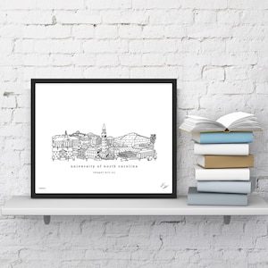 May include: Black and white line art print of the University of North Carolina campus, including the iconic bell tower and the Dean E. Smith Center. The text "university of north carolina" and "chapel hill nc" is printed below the image.
