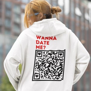 May include: White hoodie with the text "Wanna Date Me?" and a black and white QR code with three small hearts on the back.