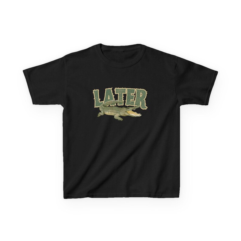 May include: Black t-shirt featuring a green alligator graphic with the word "LATER" in a matching green, textured font. The alligator is depicted with its mouth open. The shirt is a casual wear item.