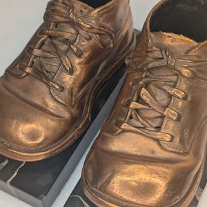 Chaussures bébé vintage des années 1950 bronzées sur une base en marbre noir
