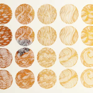 Op de afbeelding: Twintig gouden cirkels met verschillende patronen van lijnen en swirls op een witte achtergrond.