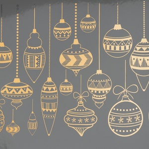 Peut inclure: Une collection de 15 boules de Noël dorées avec différents motifs géométriques et des dessins suspendus à des cordes sur un fond gris.