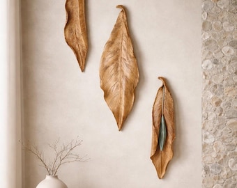 Escultura de cerámica para pared. Decoración orgánica y terrosa inspirada en la naturaleza, con hojas grandes.