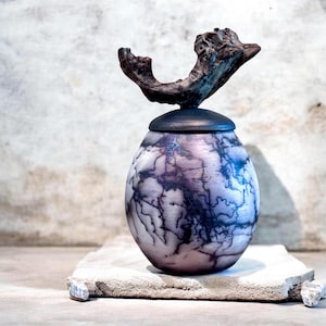 Urna orgánica de cerámica raku con crin de caballo. Frasco rústico de cerámica con tapa y asa de madera flotante.