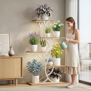 May include: A multi-tiered plant stand featuring a white metal frame with curved supports and light wood shelves. The stand holds various potted plants, including a begonia, lavender, snake plant, and succulents in white ceramic pots.