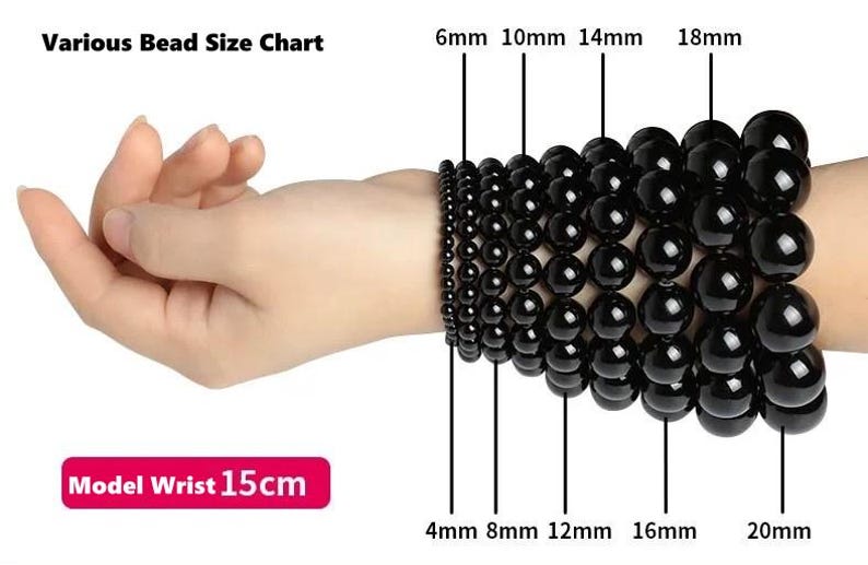 May include: A bead size chart showing various sizes of black beads, from 4mm to 20mm, displayed on a wrist. The text "Various Bead Size Chart" is at the top. The text "Model Wrist 15cm" is at the bottom.