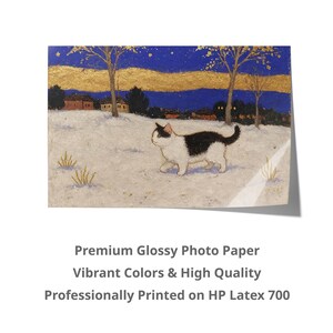 May include: A black and white cat walks through a snowy landscape with a village in the background. The sky is blue with gold stars and a yellow sunset. The image is printed on premium glossy photo paper.