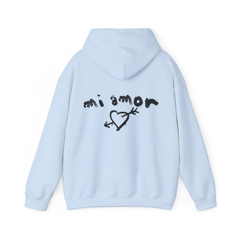 K&ouml;nnte beinhalten: Ein hellblauer Hoodie mit einem schwarzen Grafikdruck auf der R&uuml;ckseite, der "mi amor" mit einem Herz und einem Pfeil sagt.