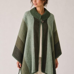 Puede incluir: Un poncho verde y oliva con diseño a rayas. Cuenta con un cuello de punto y un cierre de botón único. La prenda está confeccionada con una tela suave y texturizada, ideal para combinar.