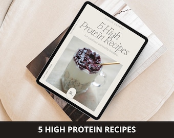 May include: A digital tablet displaying a cookbook cover titled "5 High Protein Recipes" by Judith Kramer. The image features a layered breakfast parfait in a clear glass with a gold spoon. The tablet rests on a stack of books.