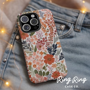 May include: A floral phone case with a white background and a pattern of orange, pink, and blue flowers and green leaves. The case has a camera cutout and the text "Ring Ring CASE CO."