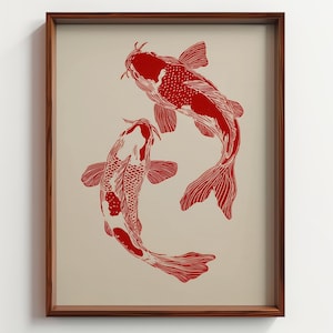 May include: A framed print featuring two red koi fish swimming in opposite directions on a beige background. The fish are detailed with scales and fins, and the frame is made of dark wood. The artwork has a minimalist, Asian-inspired aesthetic.