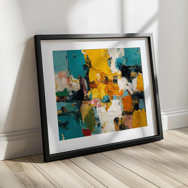 May include: An abstract painting in a black frame. The artwork features bold brushstrokes of teal, yellow, white, orange, and black. The painting is leaning against a white wall on a wooden floor, creating a modern art display.