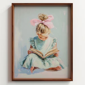 May include: A framed art print depicts a young child engrossed in a book. The child, with blonde hair and a pink bow, wears a light blue dress. The artwork has a soft, painterly style, with a brown wooden frame.