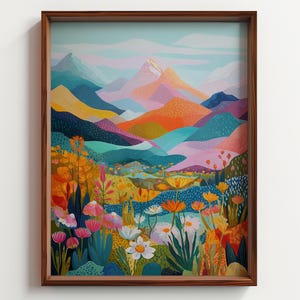 May include: A framed art print featuring a colorful landscape. The artwork depicts a mountain range with peaks in shades of pink, orange, and blue. The foreground is filled with wildflowers in yellow, pink, and white. The frame is made of brown wood.