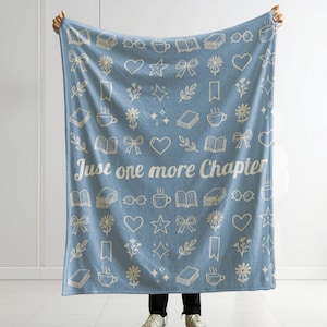 May include: A light blue throw blanket featuring a repeating pattern of white line-art icons including books, coffee cups, hearts, stars, bows, and flowers. The text "Just one more Chapter" is printed in white across the center of the blanket.
