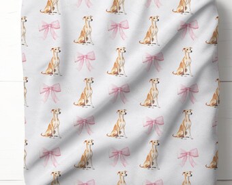 Könnte beinhalten: Weißer Stoff mit einem sich wiederholenden Muster aus hellbraunen Hunden und rosa Schleifen. Die Hunde sind im Sitzen dargestellt, und die Schleifen sind zartrosa. Der Stoff ist gefaltet und zeigt das Muster auf der Vorderseite.
