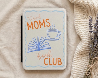 May include: A rectangular e-reader case with a white textured surface and a light blue wavy border. The front features the orange text "tired MOMS" and "Book CLUB" with a blue line drawing of an open book and a steaming cup of coffee in between.