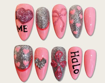 Uñas postizas rosas con diseño de corazones y lazos brillantes / Uñas postizas de San Valentín