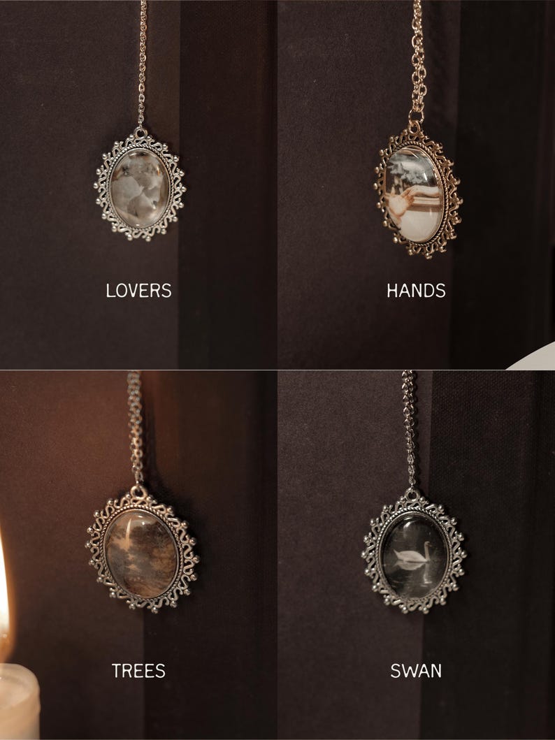 May include: Four ornate, silver-toned pendants with oval-shaped centers and delicate chain attachments. Each pendant features a different image: a cloudy stone, a couple, a tree-like pattern, and a swan. The word "LOVERS", "HANDS", "TREES", and "SWAN" are printed below each pendant.