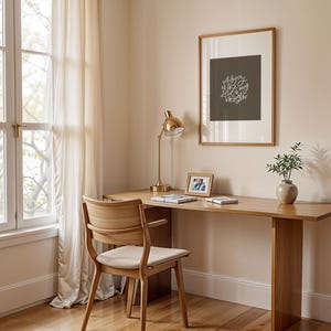 Pode incluir: Uma secret&aacute;ria de madeira clara com uma cadeira a condizer est&aacute; colocada perto de uma janela com cortinas transparentes. Uma l&acirc;mpada de secret&aacute;ria dourada, arte emoldurada com texto, uma pequena moldura e um vaso com vegeta&ccedil;&atilde;o est&atilde;o na secret&aacute;ria.
