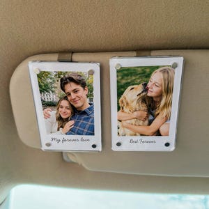 May include: Two clear acrylic photo holders with metal clips, each displaying a photograph. One shows a couple with the text "My forever love." The other shows a girl with a dog, with the text "Best Forever."