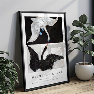 Peut inclure: Une impression d'art encadrée représentant The Swan No. 1, 1915 de Hilma af Klint. L'image montre un cygne blanc sur fond noir et un cygne noir sur fond blanc, leurs becs se touchant. Le texte en bas indique HILMA AF KLINT.