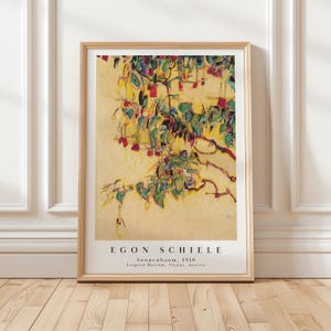 May include: A framed art print featuring Egon Schiele's painting Sonnenbaum, 1910. The artwork displays a stylised tree with green leaves and red accents against a pale yellow background. The text reads Egon Schiele, Sonnenbaum, 1910, Leopold Museum, Vienna, Austria.