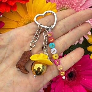 Llavero con dije de bota y sombrero de vaquera – Llavero personalizado con nombre del oeste – Precioso dije para bolso campestre – Cuentas con letras de colores – Regalo para ella