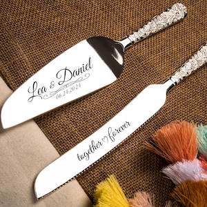Può includere: Un set di coltello e server per torta in argento con testo inciso. Il coltello ha il testo "together forever" e il server ha il testo "Lea & Daniel 06.24.2024".