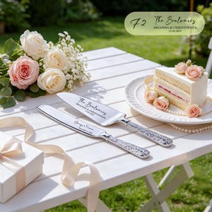 May include: A silver cake knife and server set with ornate handles. The server is engraved with "The Boulwares BRIANNA & CHRISTOPHER 12.03.2025" and the knife is engraved with "Always & Forever December 3, 2025". The set is placed on a white table.
