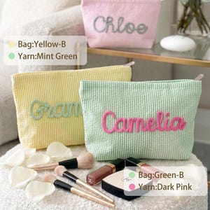 May include: Three seersucker zipper pouches in pink, yellow, and mint green. The pink pouch features the name Chloe in grey, the yellow pouch has the name Gram in mint green, and the mint green pouch displays the name Camelia in dark pink.