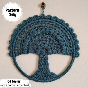 May include: A teal blue crocheted tree wall hanging with a wooden bead at the top. The pattern is written in US terms with a conversion chart. The text "Pattern Only" is written in white on a black circle.