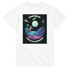 Może przedstawiać: Biała koszulka z kolorową grafiką przedstawiającą astronautę unoszącego się w surrealistycznej scenerii kosmicznej. Projekt zawiera planety, żywy krajobraz i napis "Tripping in Parallel Universe."