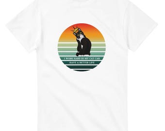 May include: White t-shirt with a black and white cat wearing a gold crown sitting in front of a sunset with the text "I work hard so my cat can have a better life."