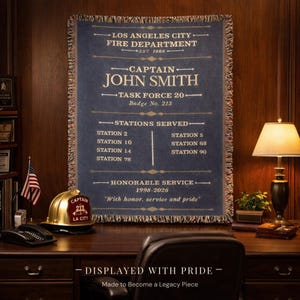 Pode incluir: Uma tapeçaria azul marinho com texto dourado, comemorando o Capitão John Smith do Departamento de Bombeiros da Cidade de Los Angeles. A tapeçaria lista as estações servidas, as datas de serviço e o texto "Com honra, serviço e orgulho."