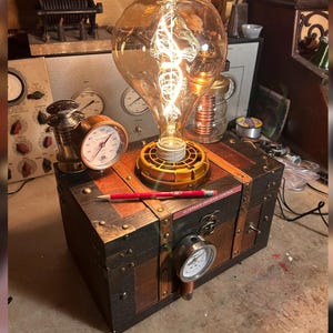 May include: Steampunk-style lamp with a large Edison bulb, set atop a wooden chest with metal accents and gauges. A red pencil rests on the chest, and the text "ALTERNATE UNIVERSE CONTROL" is visible. The lamp has a brass base and a warm, inviting glow.