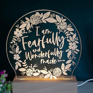 May include: A white acrylic night light with a floral design and the text "I am fearfully and wonderfully made - Psalm 139:14". The light is on a wooden base.