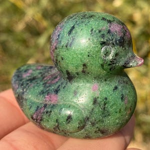 Könnte beinhalten: Grüne, schwarze und rosafarbene Edelsteinfigur in Form einer Ente.