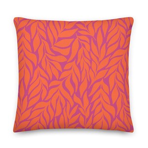 May include: Orange and pink throw pillow with a leaf pattern.