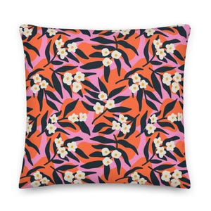 May include: A pink and orange throw pillow with a floral pattern featuring white flowers and dark green leaves.