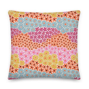 May include: A decorative throw pillow with a floral pattern. The pillow features a white background with a repeating pattern of pink, orange, yellow, and blue flowers.